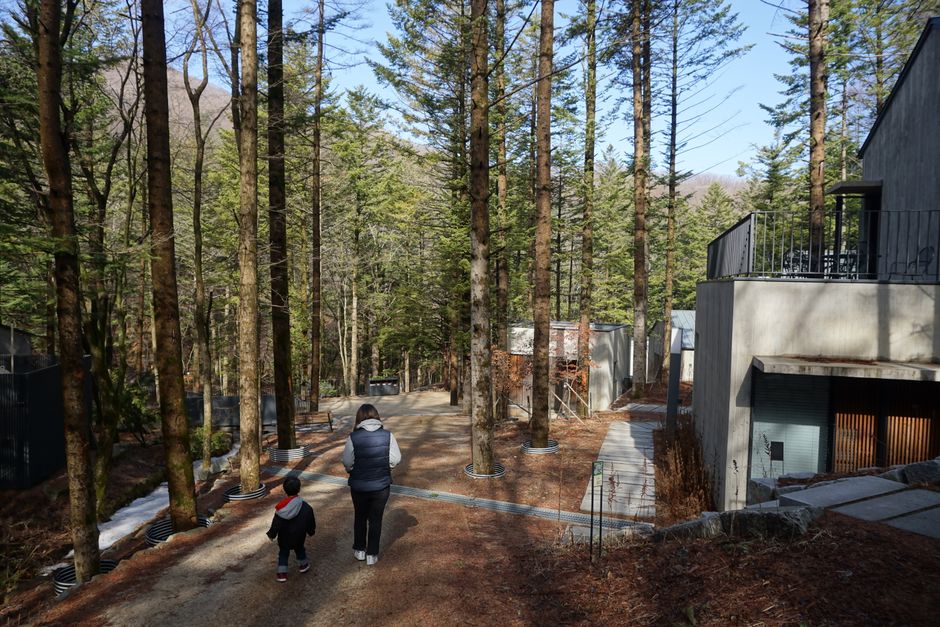 새 아파트 거실에서 행복하게 웃고 있는 젊은 가족이 태블릿을 보고 있는 모습, 주택청약 특별공급 성공을 상징